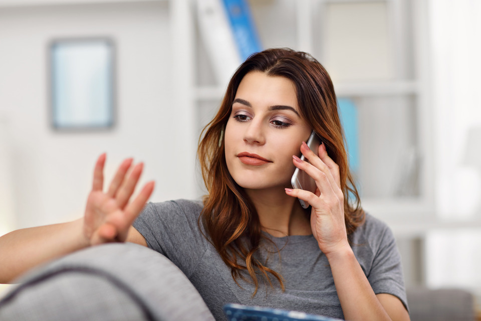 woman listening in an on-hold message | Featured image of the Custom On Hold Messages