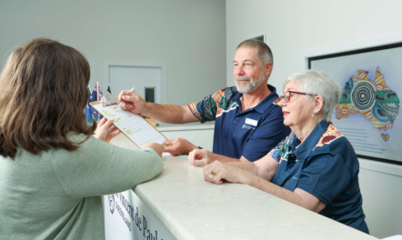 St Vincent de Paul volunteers assisting someone behind a desk.