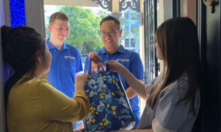 St Vincent de Paul volunteers delivering bag to two women inside a house