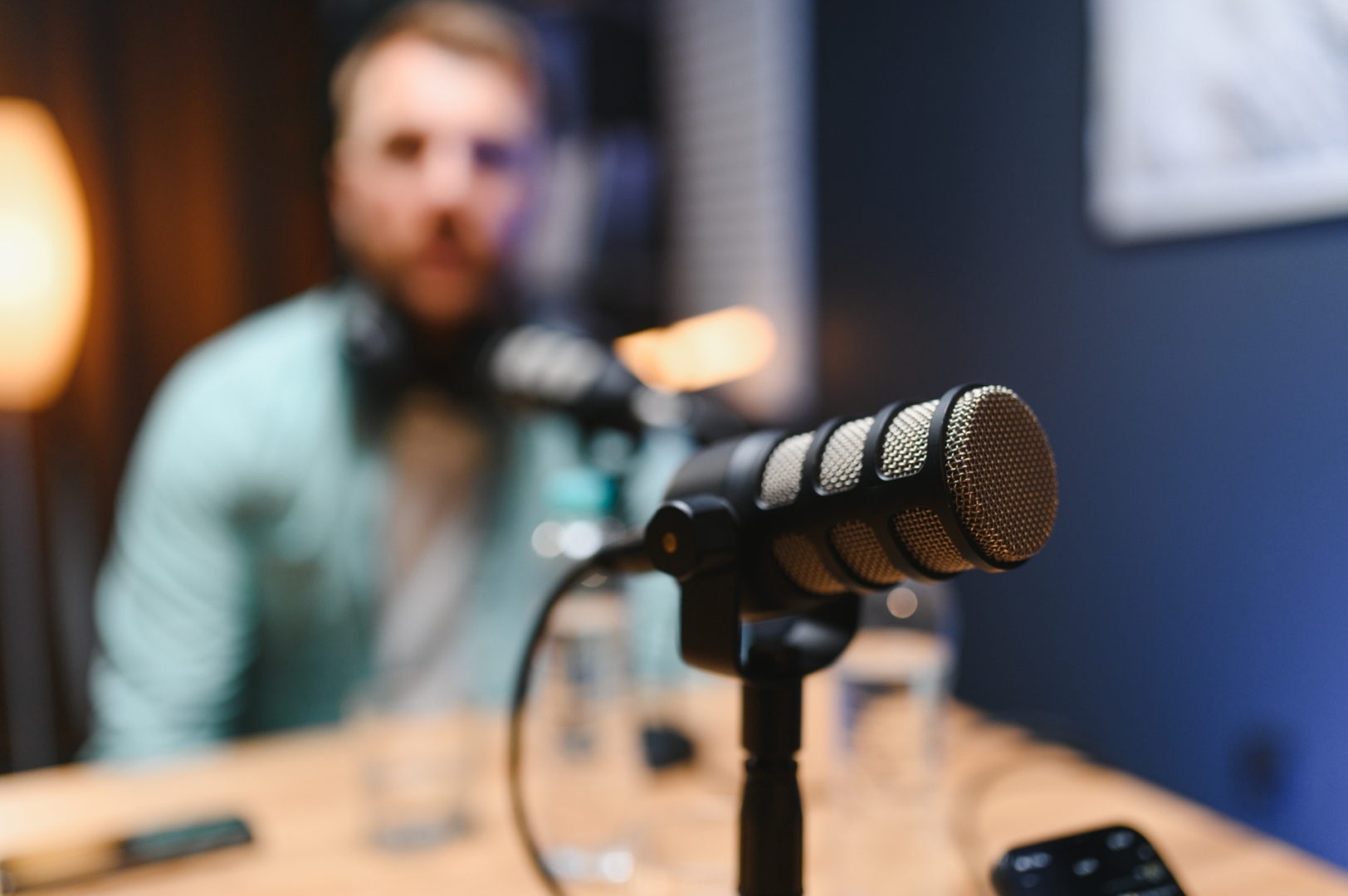 Man Recording Podcast with Microphone in Home Studio | Featured Image for the The Importance of Professional IVR Voice Recordings for Your Business blog.